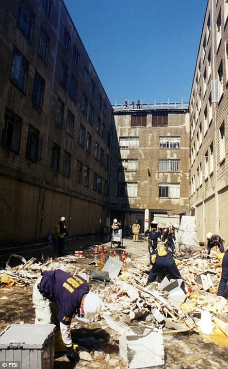 Pictured above is members of the FBI and firefighters removing the carnage of the Pentagon after the attack