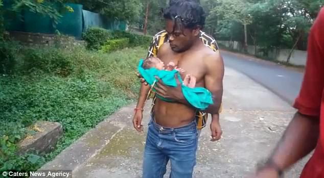 Her hero: Dheeraj Rathore, who runs a tea stall, heard the baby cry from a bin in some bushes in Bhopal in the central Indian state of Madhya Pradesh